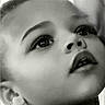 child, portrait, black_and_white, face, curly_hair, looking_up, innocence, close_up, soft_light, expression, young_child, monochrome, curtain, young_face, innocent, candid, childhood, thoughtful, profile, emotion