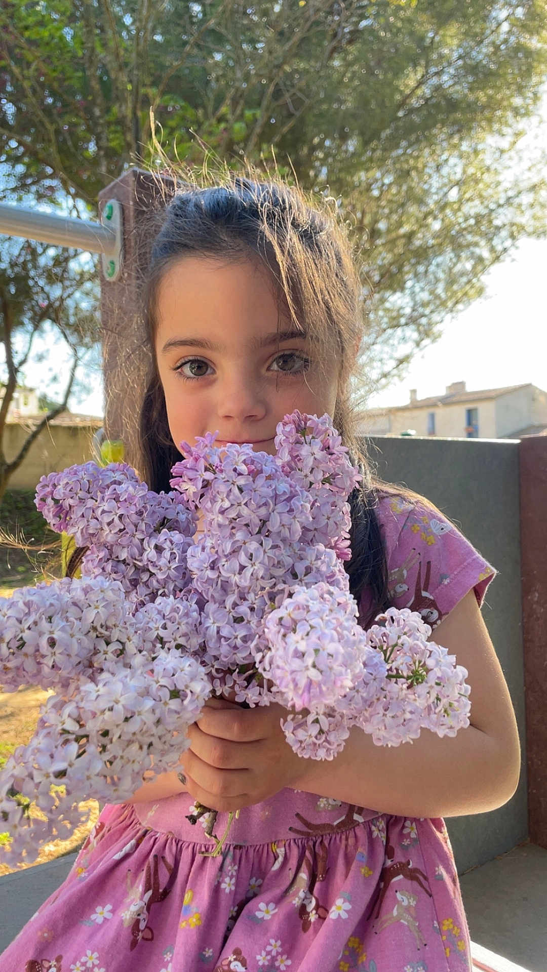Ohana a rejoint le concours — aidez-le/la à gagner de superbes lots ! child, girl, flower_bouquet, lilac, pink_dress, outdoor, sunlight, tree, nature, portrait, smile, holding, spring, garden, happy, floral_pattern, daylight, cute, young, person
