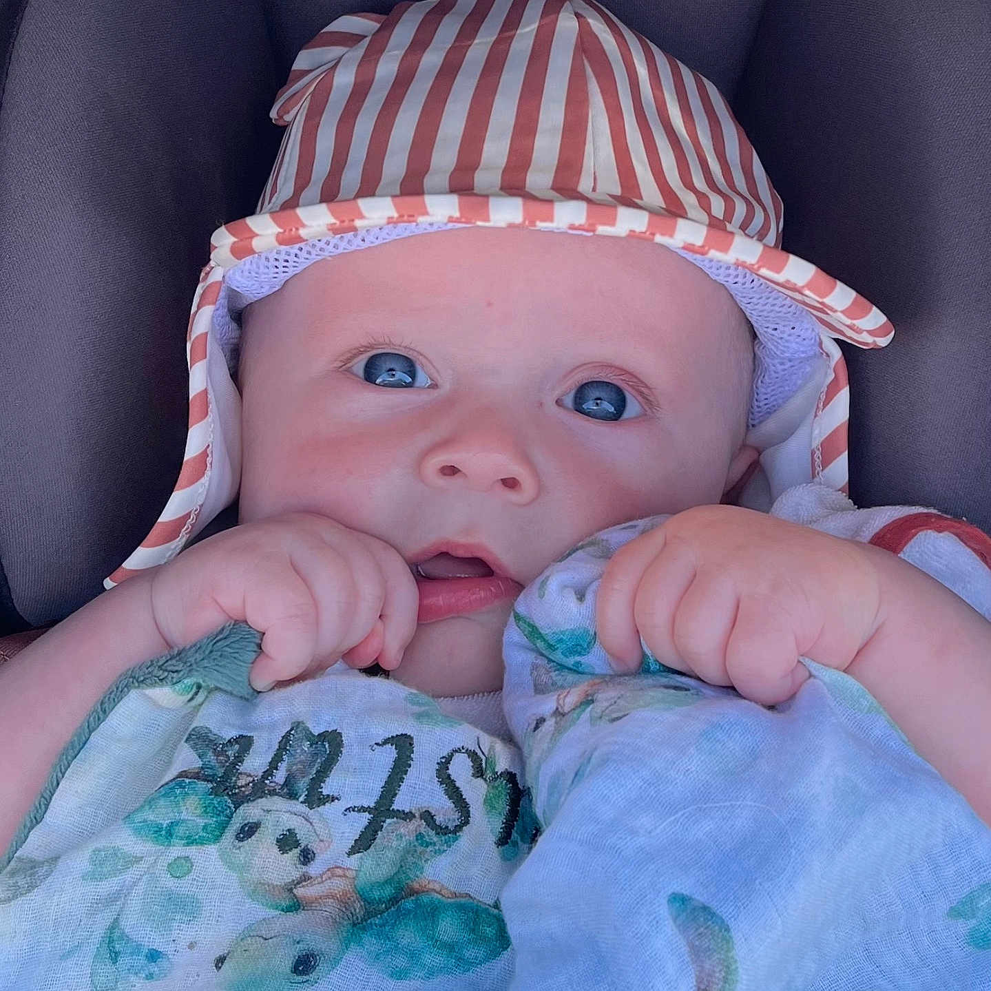 Justin a rejoint le concours — aidez-le/la à gagner de superbes lots ! baby, baby_face, blanket, blue_eyes, chair, child, closeup, clothing, comfort, cushion, cute, hand, hat, indoors, infant, person, portrait, sea_turtle, soft_lighting, striped_hat