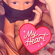 Haislyn is registered to the contest to win money with this photo: child, face, eyes, hand, black_cloth, heart_sticker, baby_bottle, arm, skin, indoors, person, cute, playful, closeup, young_child, expression, baby, covering_face, affection, warm_lighting