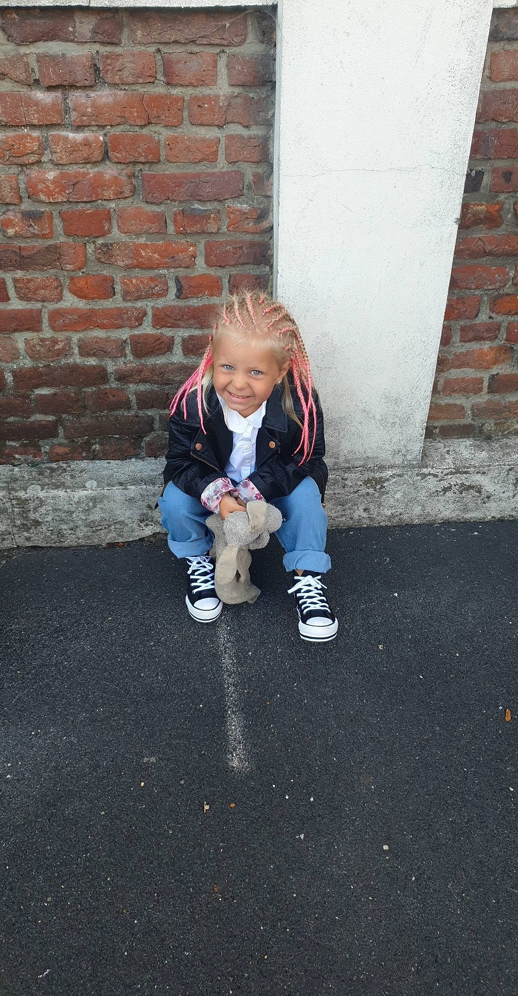 Enora participe au concours pour gagner de l'argent avec cette photo : asphalt, brick, brickwork, child, city, electric_blue, floor, flooring, fun, grass, human_body, human_leg, jacket, joy, person, road, road_surface, shoe, sidewalk, sitting