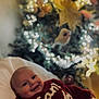 baby, smiling, red_sweater, blanket, christmas_tree, lights, indoor, holiday, festive, child, portrait, cozy, decorations, blurred_background, happy, person, infant, warm, seasonal, celebration