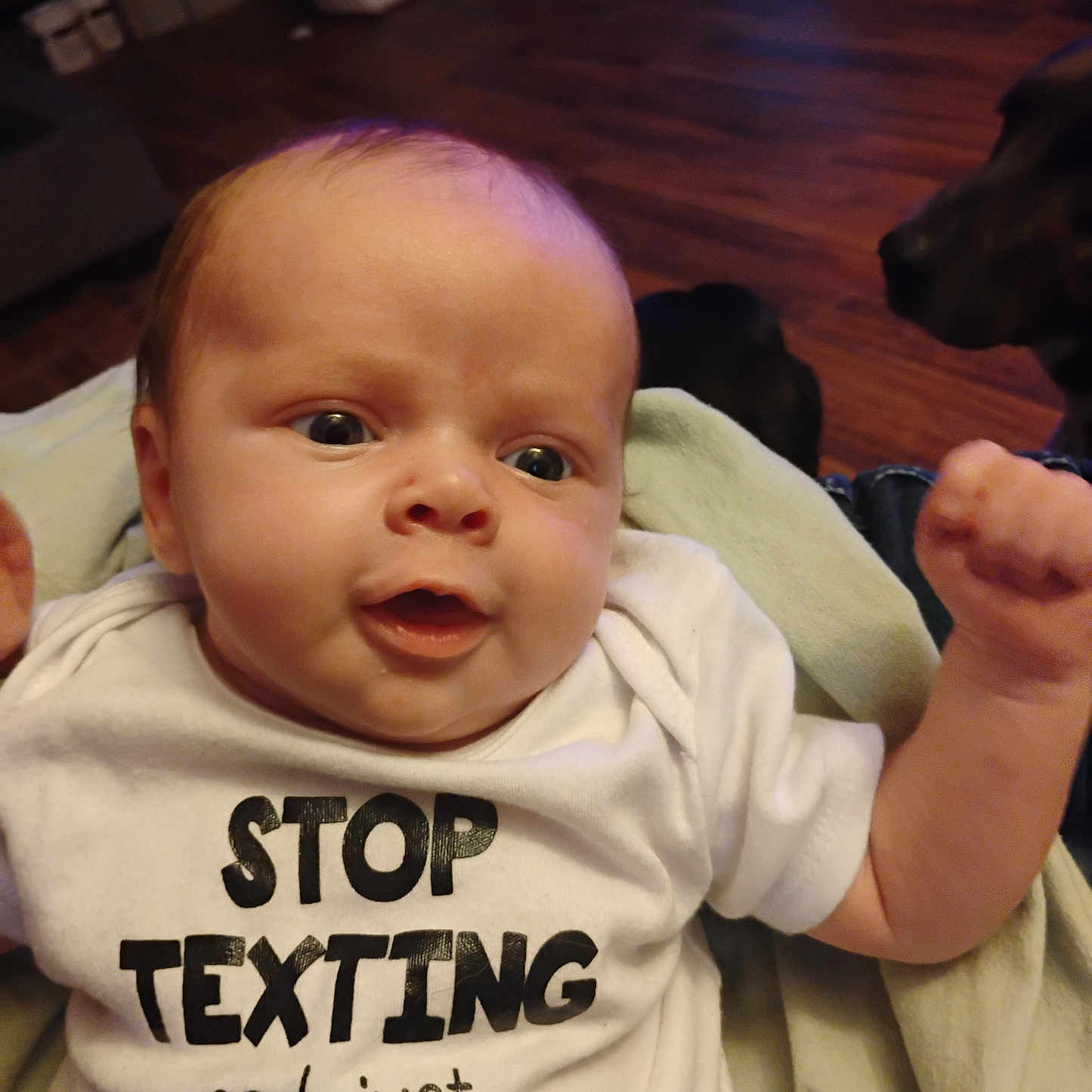 River joined the competition — help win amazing prizes! baby, bodypart, clothing, couch, face, finger, furniture, hand, hardwood, head, mouth, newborn, pattern, person, photography, portrait, shirt, sitting, t_shirt, wood