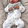Psalm is registered to the contest to win money with this photo: baby, infant, pacifier, onesie, striped_bib, animal_prints, blanket, bed, sleepy, relaxed, cute, child, clothing, lying_down, soft_texture, hands, face, head, indoors, portrait