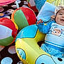 Anthony is registered to the contest to win money with this photo: baby, infant, smile, hat, blue_clothing, inflatable_ring, beach_balls, toy, blanket, polka_dots, two_months, happy, child, playtime, outdoor, sunlight, cute, face, lying_down, colorful