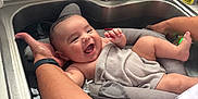 Anthony is registered to the contest to win money with this photo: baby, infant, smile, bath, sink, kitchen, towel, water, arm, adult, support, happy, cute, indoors, person, skin, expression, care, cleaning, family