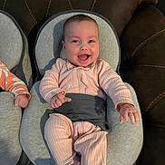 Sophia joined the competition — help win amazing prizes! baby, infant, smiling, pink_outfit, bouncer_seat, baby_seat, couch, living_room, happy, cheerful, chubby_cheeks, bright_eyes, hands, legs, portrait, textured_fabric, stitching, seatbelt, indoor, cute