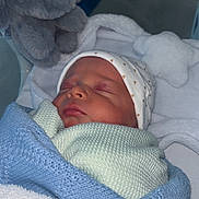 Mateo is registered to the contest to win money with this photo: newborn, baby, sleeping, blanket, hat, plush_toy, elephant, soft, cozy, infant, wrapped, cute, peaceful, bed, resting, child, portrait, indoors, warm, toddler