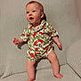 Elijah is registered to the contest to win money with this photo: baby, child, dinosaur_print, clothing, infant, standing, blanket, cute, expression, face, person, texture, home, comfort, legs, feet, happy, young, indoor, curious