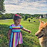 child, toddler, dog, grass, outdoor, sky, clouds, dress, colorful_clothing, pink_crocs, trees, house, smiling, pet, nature, sunny, portrait, playing, animal, happy