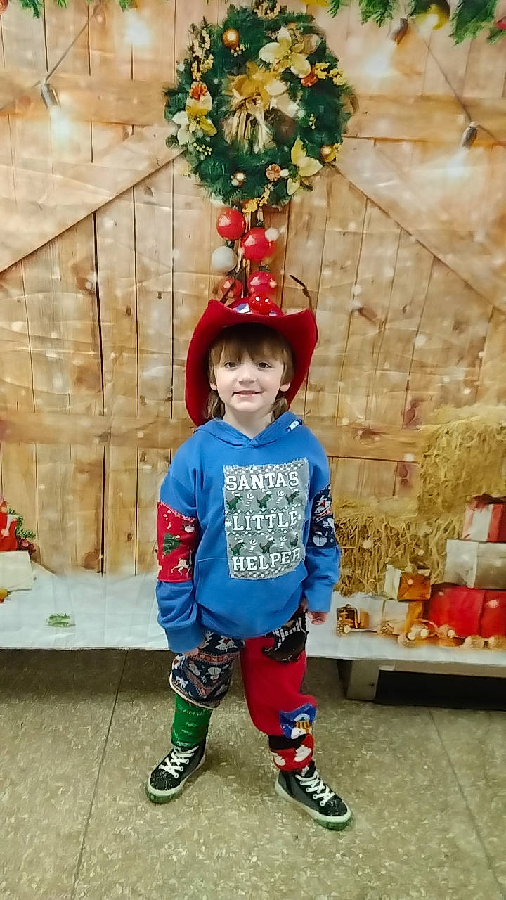 Caleb is registered to the contest to win money with this photo: christmas_decoration, christmas_ornament, event, eye, happy, hat, holiday, holiday_ornament, joy, leisure, orange, person, photograph, red, shoe, sleeve, smile, snapshot, toddler, tree