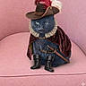 cat, costume, hat, feather, ruffled_collar, cape, boots, sword, black_cat, pink_chair, indoor, pet, animal, feline, portrait, fancy_dress, seated, cute, whiskers, mustache