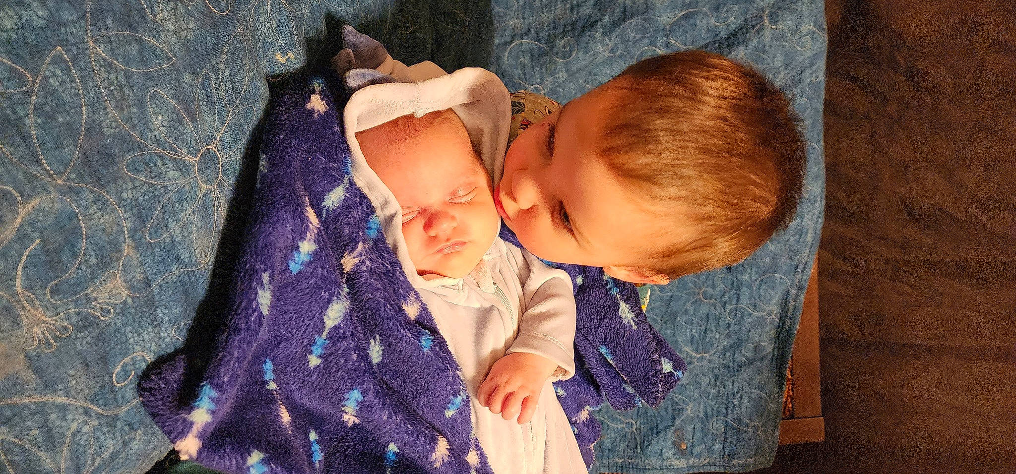 Lucca is registered to the contest to win money with this photo: baby, baby_toddler_clothing, cheek, child, comfort, ear, finger, fun, gesture, hand, happy, iris, lip, nose, person, purple, sitting, skin, toddler, tree