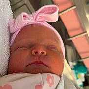 Oaklee is registered to the contest to win money with this photo: newborn, baby, sleeping, pink, headband, bow, blanket, flower_pattern, infant, closeup, face, wrapped, cozy, soft_lighting, hospital, indoor, cute, peaceful, skin, portrait