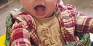 Tatum is registered to the contest to win money with this photo: baby, child, smiling, plaid_shirt, baby_walker, toy, elephant_plush, indoor, happy, infant, clothing, playtime, colorful, mouth_open, cheerful, person, cute, head, face, young