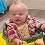 baby, infant, walker, toy, elephant_toy, plaid_shirt, indoor, floor, child, person, clothing, hand, face, hair, expression, seat, colorful, play, young_child, cute