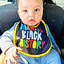 Kyrie is registered to the contest to win money with this photo: baby, infant, child, car_seat, bib, colorful, clothing, striped_pajamas, hand, face, eyes, mouth, car_interior, seat, sitting, young, cute, portrait, expression, bright