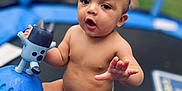 Colby is registered to the contest to win money with this photo: baby, child, diaper, toy, trampoline, outdoor, infant, play, cute, skin, hand, face, expression, sitting, background, blur, car, greenery, summer, fun