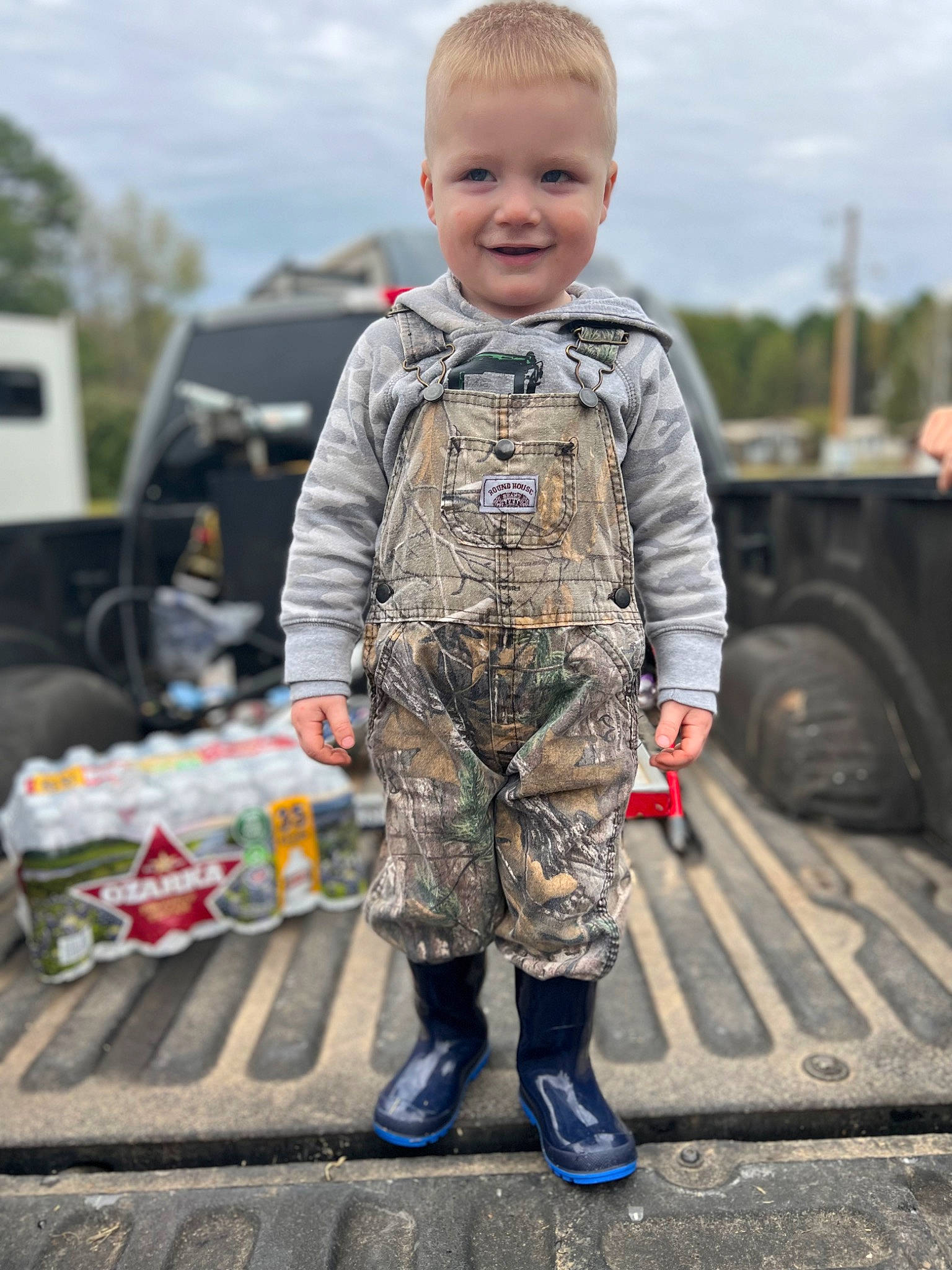 Greyson Level is registered to the contest to win money with this photo: army, asphalt, cloud, eye, face, jacket, joy, military_camouflage, military_person, military_uniform, motor_vehicle, non_commissioned_officer, person, road_surface, sky, sleeve, smile, soldier, tire, toddler