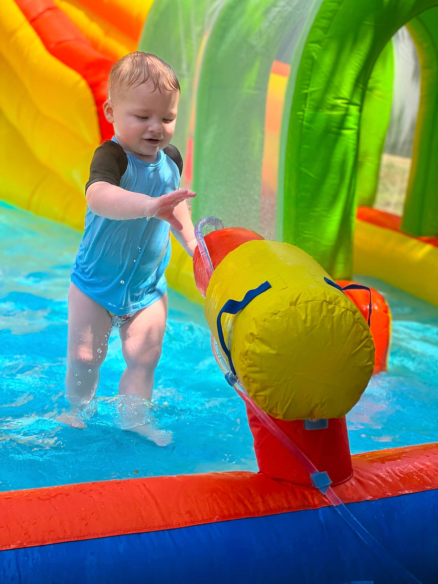 Greyson Level is registered to the contest to win money with this photo: aqua, blue, child, chute, fun, green, happy, inflatable, leisure, nonbuilding_structure, outdoor_play_equipment, person, photograph, play, playground, recreation, snapshot, toddler, water, world