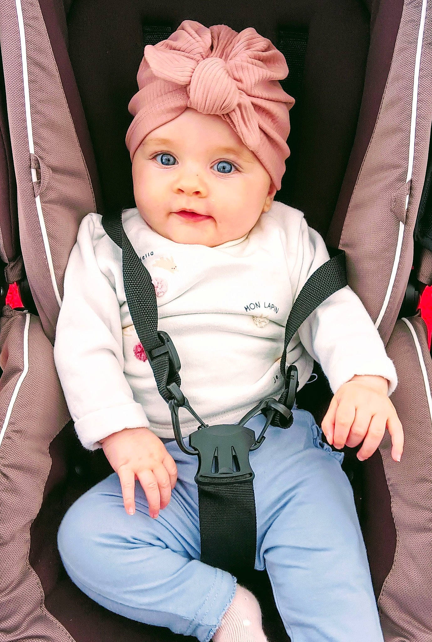 Rose participe au concours pour gagner de l'argent avec cette photo : baby, baby_carriage, baby_products, baby_toddler_clothing, beanie, cap, car_seat, cheek, child, comfort, costume_hat, eye, face, fashion_accessory, finger, hat, headwear, person, seat_belt, sitting