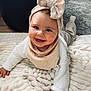 Zélie a rejoint le concours — aidez-le/la à gagner de superbes lots ! baby, smiling, headband, bib, blanket, indoor, child, cute, happy, crawling, person, face, clothing, soft_texture, floor, toy, warm_colors, cozy, infant, living_room