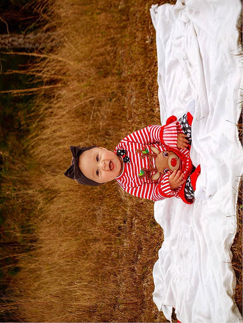 Paisley is registered to the contest to win money with this photo: art, baby, baby_toddler_clothing, carmine, child, dress, fashion_design, formal_wear, grass, happy, headwear, illustration, pattern, people_in_nature, person, sleeve, toddler, tradition, tree, vintage_clothing