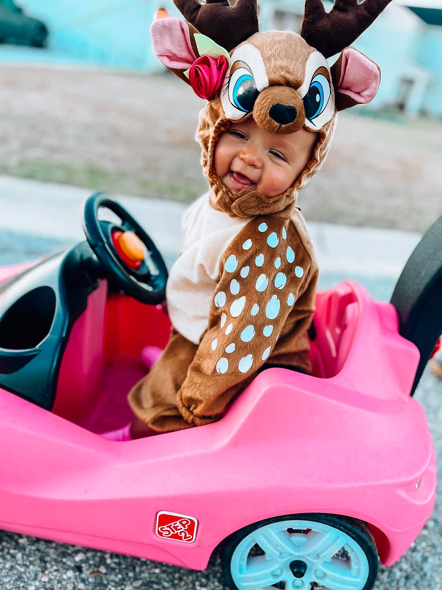 Paisley is registered to the contest to win money with this photo: automotive_design, blue, car, eyewear, fawn, green, happy, headwear, magenta, motor_vehicle, person, photograph, pink, product, red, riding_toy, tire, toy, vehicle, wheel