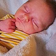 Elyo participe au concours pour gagner de l'argent avec cette photo : baby, sleeping, blanket, yellow_stripes, soft_texture, close_up, peaceful, infant, hand, face, cozy, newborn, cute, resting, portrait, child, warm, comfort, skin, fuzzy