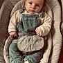 baby, infant, child, overalls, corduroy, sweater, baby_seat, plush_toy, indoor, portrait, sitting, cute, face, expression, clothing, sock, floor, furniture, comfort, young