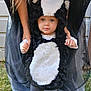 toddler, child, costume, skunk, outdoor, grass, person, legs, shoes, adult, holding_hands, black_and_white, cute, portrait, clothing, funny_costume, baby, face, standing, support