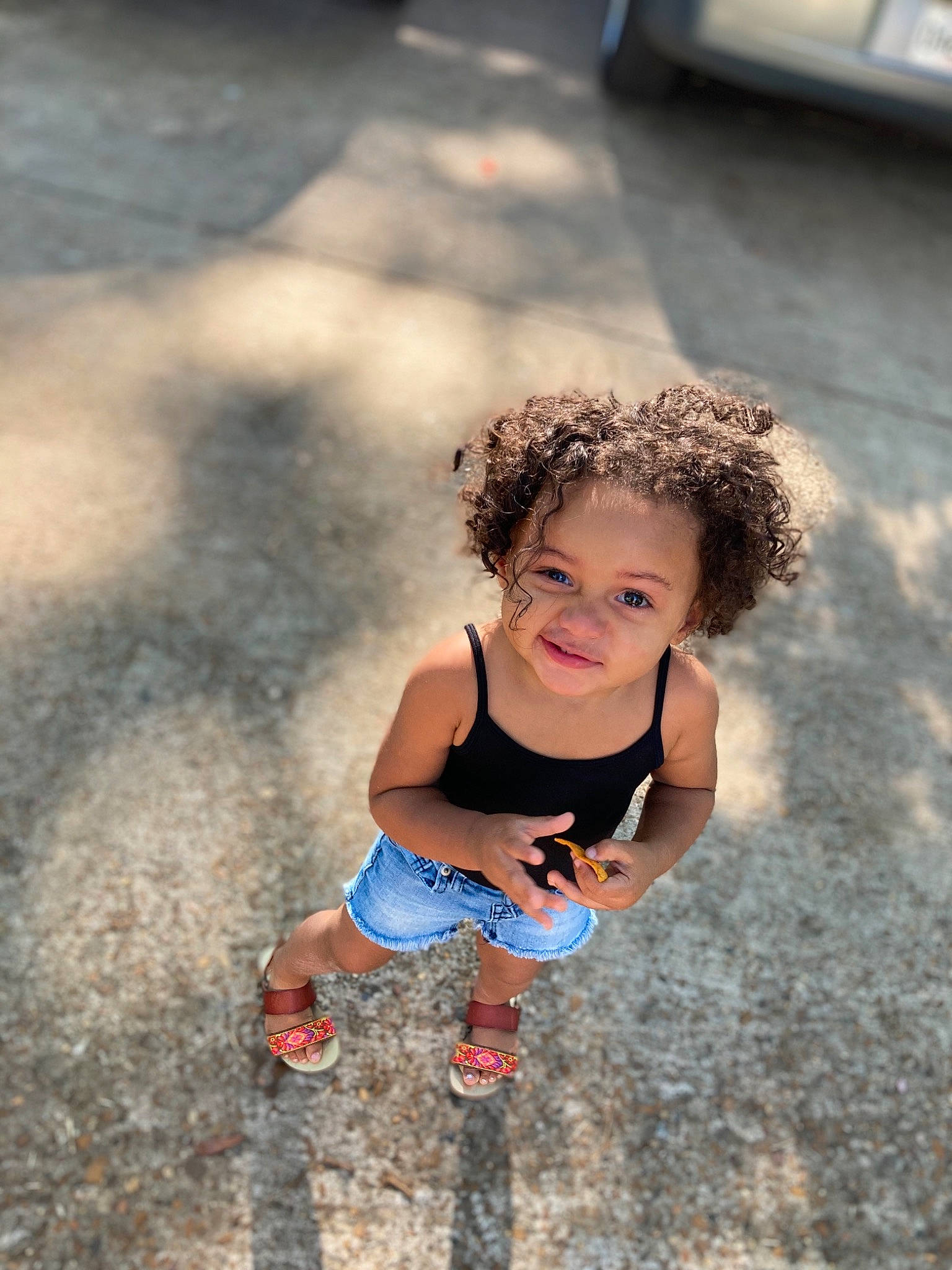 Kaniyah is registered to the contest to win money with this photo: asphalt, eye, face, flash_photography, grass, hair, hand, happy, human_body, leg, mammal, people_in_nature, person, road_surface, shoe, smile, standing, sunlight, thigh, toddler