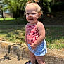 butterfly, casual_clothing, child, daylight, grass, greenery, hair_tied, happy, outdoor, portrait, sandals, shorts, sidewalk, smiling, standing, summer, sunlight, toddler, top, young_child