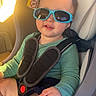 Cy is registered to the contest to win money with this photo: baby, blue, car_interior, car_seat, casual, child, cute, face, green_shirt, hand, happy, indoors, portrait, safety, seatbelt, smile, sunglasses, sunlight, toddler, young_child