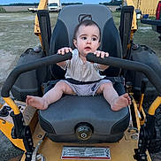 Cy joined the competition — help win amazing prizes! baby, child, expression, field, foot, grass, handlebars, lawn_mower, machine, outdoor, person, rope, rural, seat, shirt, shorts, sky, truck, vehicle, yellow