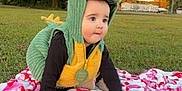 Cy joined the competition — help win amazing prizes! baby, child, dinosaur_costume, green, yellow, blanket, grass, outdoor, tree, crawling, costume, cute, infant, nature, park, play, sunset, portrait, person, fall