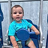 baby, blue, casual, child, cute, daylight, expression, face, hand, outdoor, playground, portrait, safety_bar, seat, shorts, summer_clothing, swing, toddler, turquoise_shirt, wooden_fence