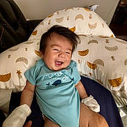 Nico joined the competition — help win amazing prizes! baby, blue_onesie, child, clothing, cushion, cute, furniture, hair, hand, happy, indoor, infant, mittens, moon_pattern, person, portrait, sitting, smiling, stars_pattern, toddler