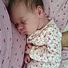 baby, sleeping, infant, onesie, flamingo_pattern, pink_blanket, cherry_prints, cozy, cute, child, newborn, soft_fabric, resting, peaceful, portrait, close_up, indoors, comfort, person, toddler