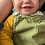 toddler, child, smiling, face, hand, overalls, green_clothing, yellow_clothing, happy, baby, person, portrait, cute, closeup, skin, indoor, casual, young_child, expression, human