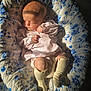 baby, sleeping, quilt, floral_pattern, pink_dress, socks, infant, cozy, sunlight, peaceful, cute, child, soft_light, portrait, resting, small_hands, blanket, indoors, newborn, comfort