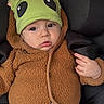 baby, child, car_seat, hat, green_hat, brown_jacket, clothing, cute, infant, face, portrait, child_seat, seatbelt, warm_clothing, expression, indoor, person, small_child, headwear, casual