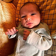 Louca participe au concours pour gagner de l'argent avec cette photo : newborn, baby, infant, face, hands, clothing, ribbed_fabric, blanket, textile, mustard, checkered, yellow, cozy, portrait, lying_down, indoors, soft_light, curious, cute, sleepwear