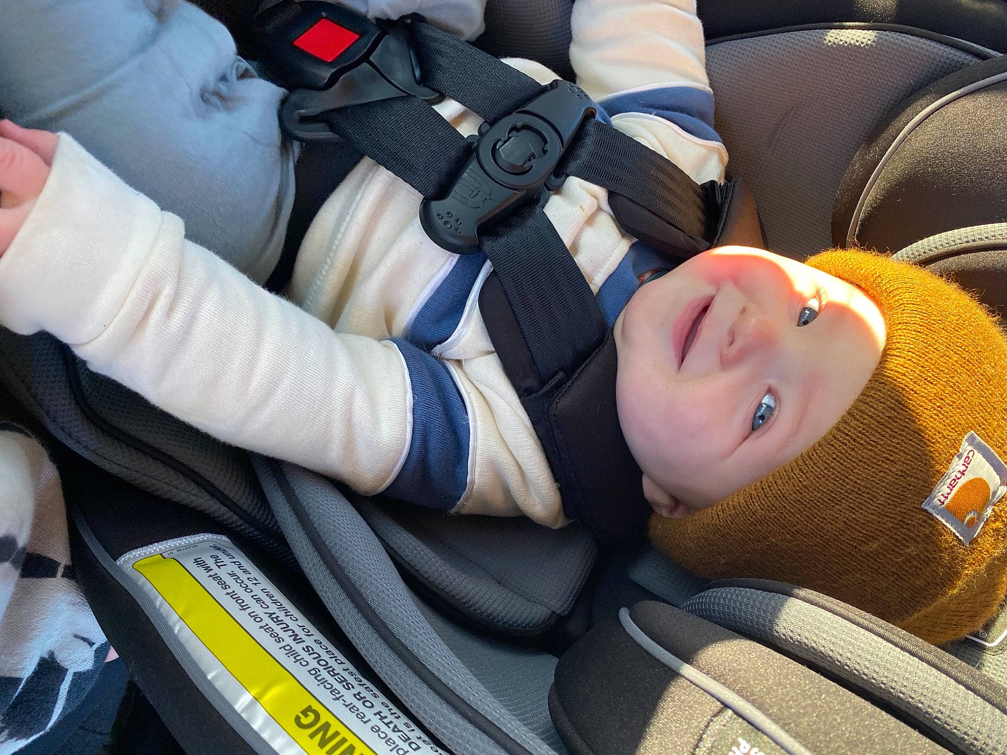 Landon is registered to the contest to win money with this photo: auto_part, automotive_design, baby_carriage, car_seat, car_seat_cover, comfort, gesture, head_restraint, headwear, joy, motor_vehicle, person, personal_protective_equipment, seat_belt, smile, sports_gear, steering_part, steering_wheel, toddler, vehicle