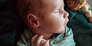 Micah is registered to the contest to win money with this photo: baby, newborn, swaddled, sleeping, infant, blanket, soft_texture, hands, face, profile, peaceful, cozy, warm_lighting, portrait, closeup, cute, resting, indoor, child, nursery