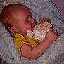Micah is registered to the contest to win money with this photo: baby, sleeping, blanket, stuffed_animal, soft, cuddly, yellow_shirt, infant, child, resting, cute, peaceful, portrait, indoor, comfort, newborn, face, hand, cozy, toddler