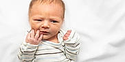 Nathan joined the competition — help win amazing prizes! baby, child, clothing, curious, cute, expression, face, furrowed_brow, hand, indoors, infant, lying_down, newborn, portrait, skin, sleepwear, small_hands, soft_texture, striped_onesie, white_blanket