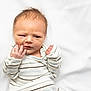 Nathan joined the competition — help win amazing prizes! newborn, baby, infant, striped_onesie, white_blanket, hand, face, expression, furrowed_brow, curious, lying_down, soft_texture, skin, portrait, cute, small_hands, indoors, child, clothing, sleepwear