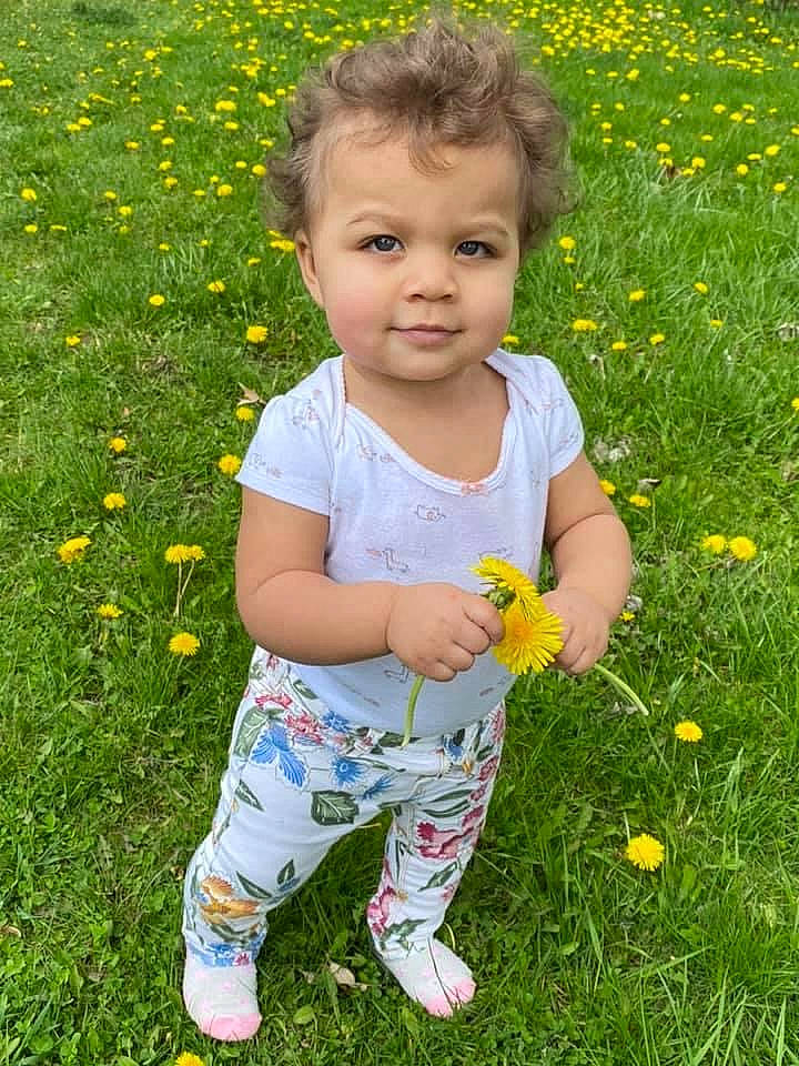 Neveah joined the competition — help win amazing prizes! baby_toddler_clothing, botany, child, facial_expression, flower, fun, grass, grass_family, grassland, green, groundcover, happy, head, leaf, meadow, people_in_nature, person, petal, plant, toddler
