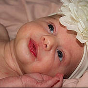 Emmy Lou is registered to the contest to win money with this photo: baby, infant, close_up, headband, flower, soft_skin, lying_down, pink_blanket, newborn, cute, portrait, face, child, small_hand, innocence, expression, young, adorable, skin, sleepy